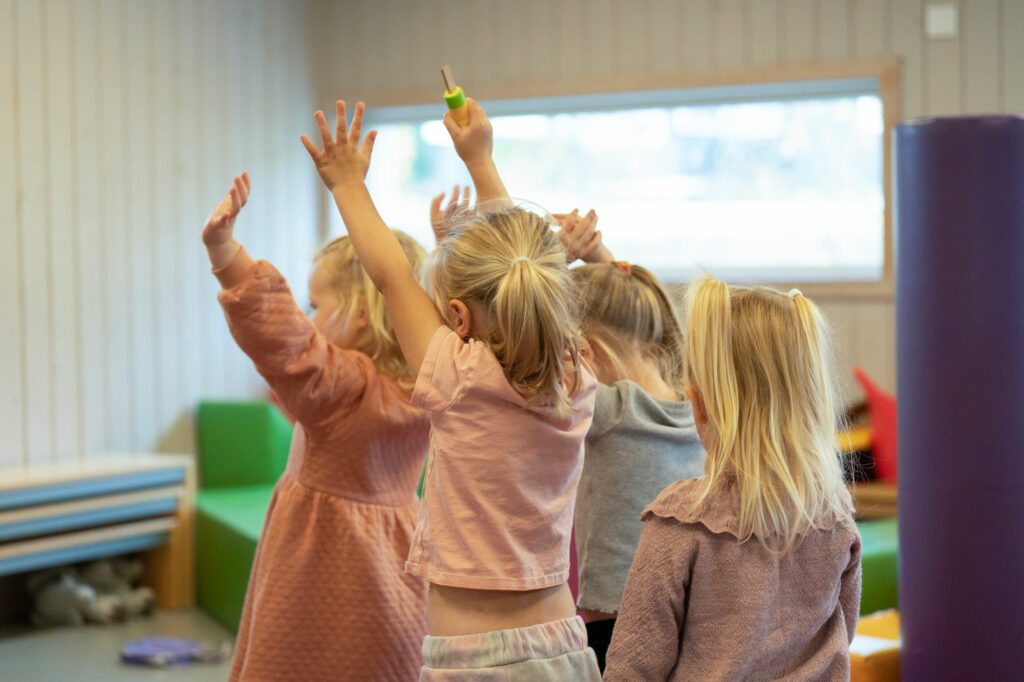 Bilde av fire jenter som danser med armene i været på Begbyenga