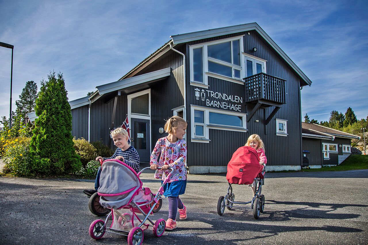 Bilde av barn som går med barnevogner utenfor Trondalen barnehage